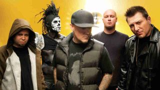 Limp Bizkit posing for a photograph against a yellow background in 2011