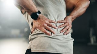 a man holding his back in pain