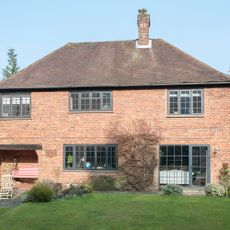 house with brick wall sash window and lawn area