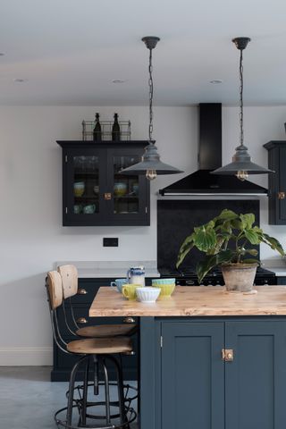 Blue kitchen with industrial style pendant lighting