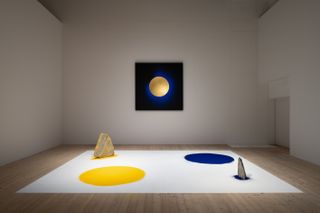 Light and Space exhibition Copenhagen contemporary featuring a white mat, a yellow and a blue circle and two objects.
