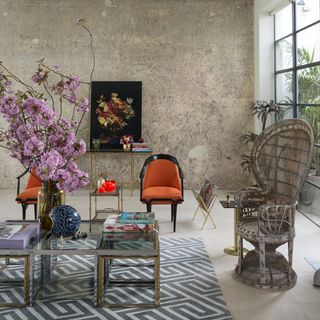 room with texture wall and orange arm chairs and flower vase
