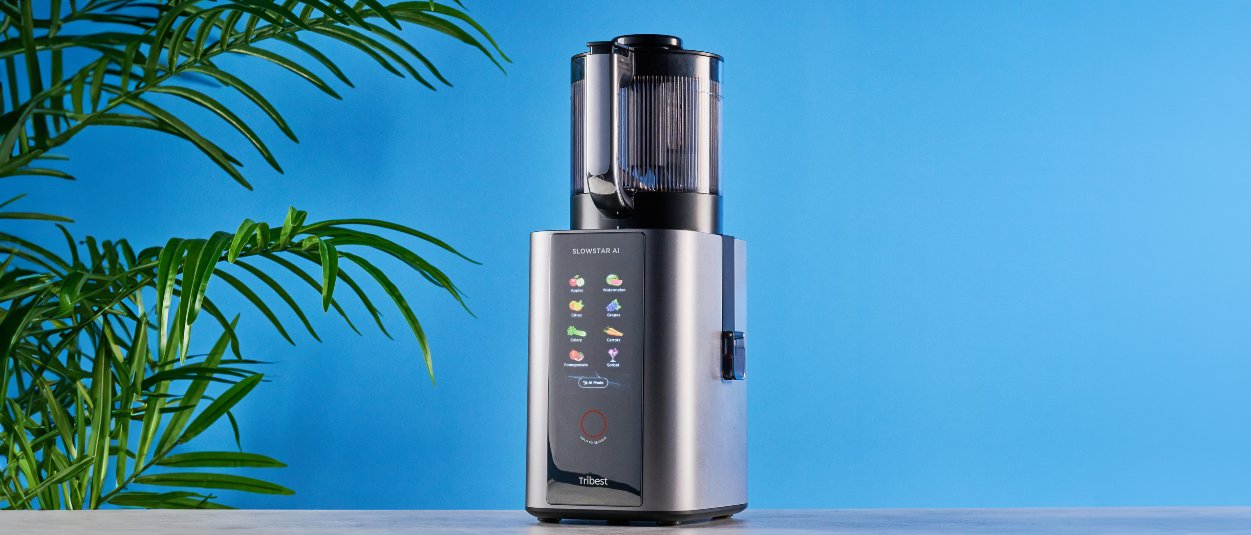 Tribest Slowstar AI Vertical Hopper Juicer photographed in front of a blue background
