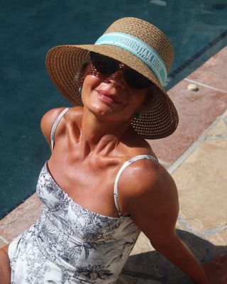 @greceghanem sitting in the sun around a swimming pool with glowing skin