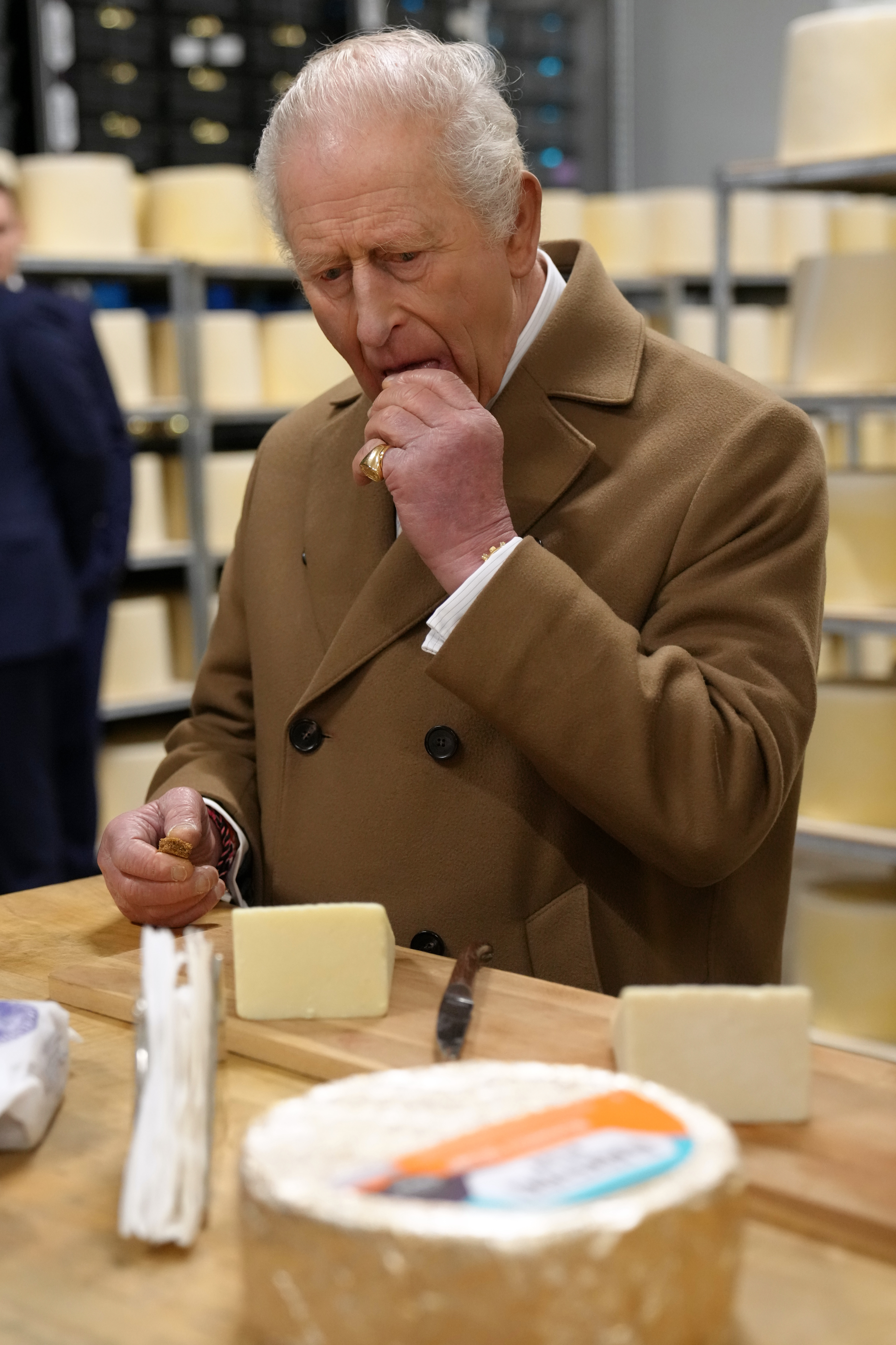 King Charles eating cheese from a table