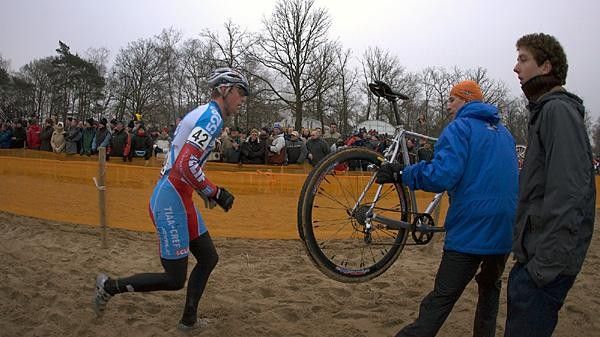 Wells gets a fresh bike from National Team Coach Geoff Proctor at the Hofstade World Cup.