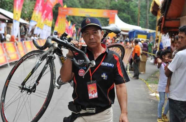 Official Tuah Sakato Cycling Team Indonesia lifted Pratama Aryi bicycle crossed the finish line. Pratama Aryi fell 30 km before the finish.