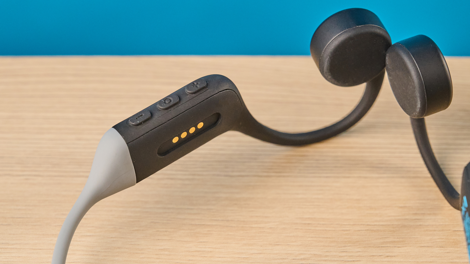 the h2o audio tri run bone conduction headphones photographed against a tom's guide blue background