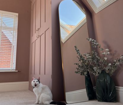 An attic room painted purple with a pitched ceiling and a built-in IKEA pax wardrobe in the corner 