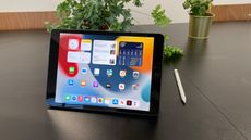 Apple iPad 10.2-inch (9th Gen) review, showing the tablet on a table, in landscape mode, with the Apple Pencil next to it