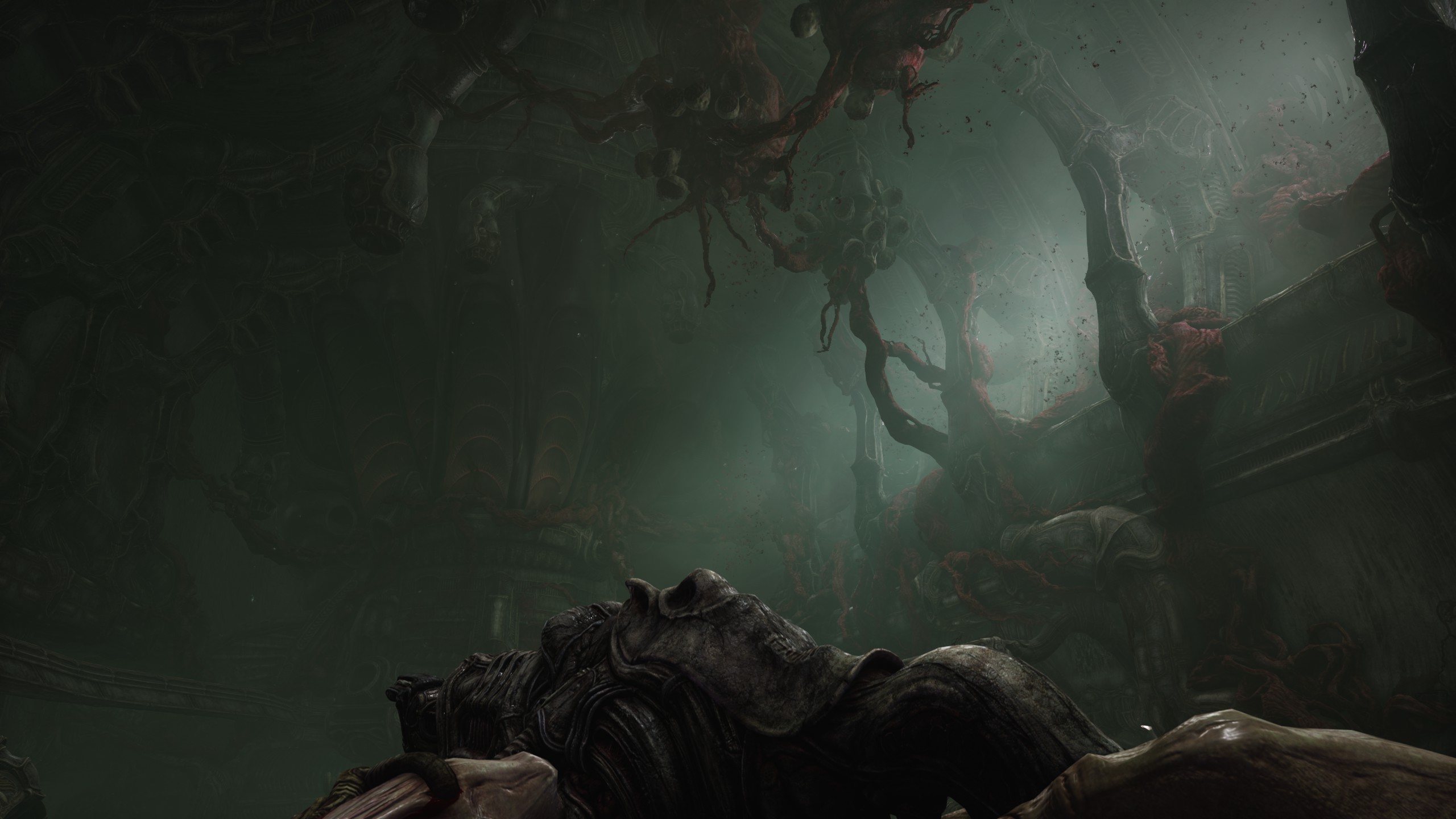 a weapon held calmly at the bottom of the screen, looking ahead through a brown Scorn corridor with pink and yellow men from a parasitic infestation hanging above.