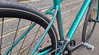 Details of reflective accents on the back of the seat stays on a green bike