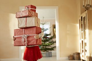 Person holding stack of christmas presents