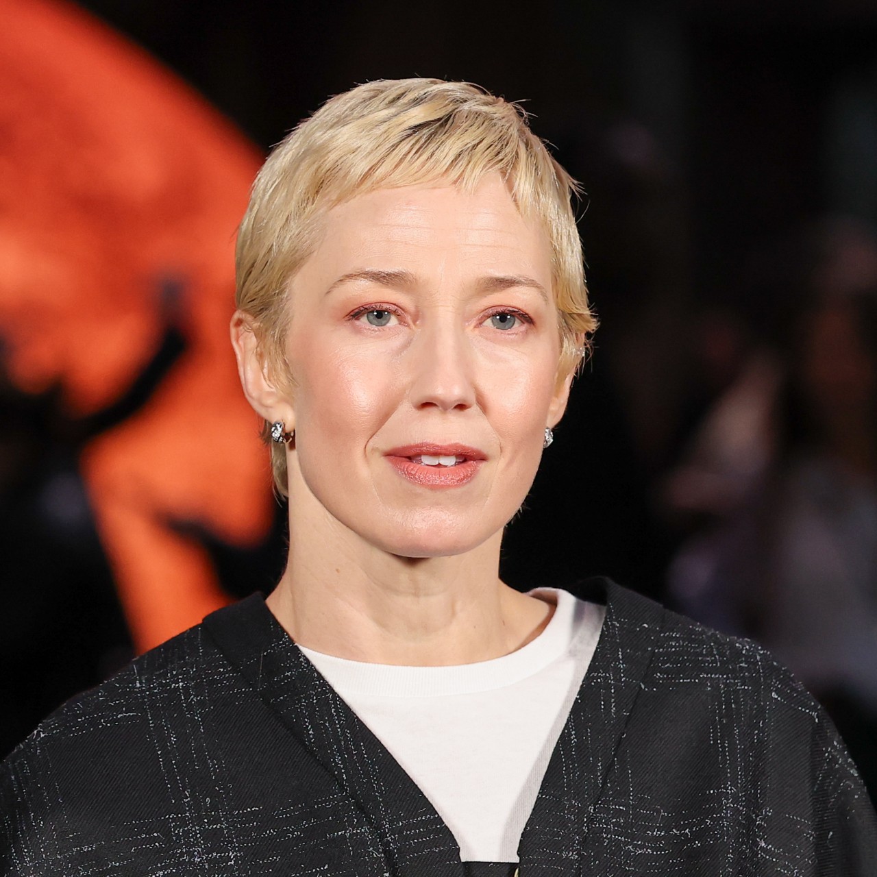 a white woman with a short, blonde haircut poses for paparazzi during a fashion week event