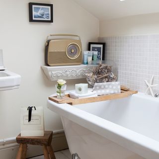 bathroom with white wall and radio with bathtub