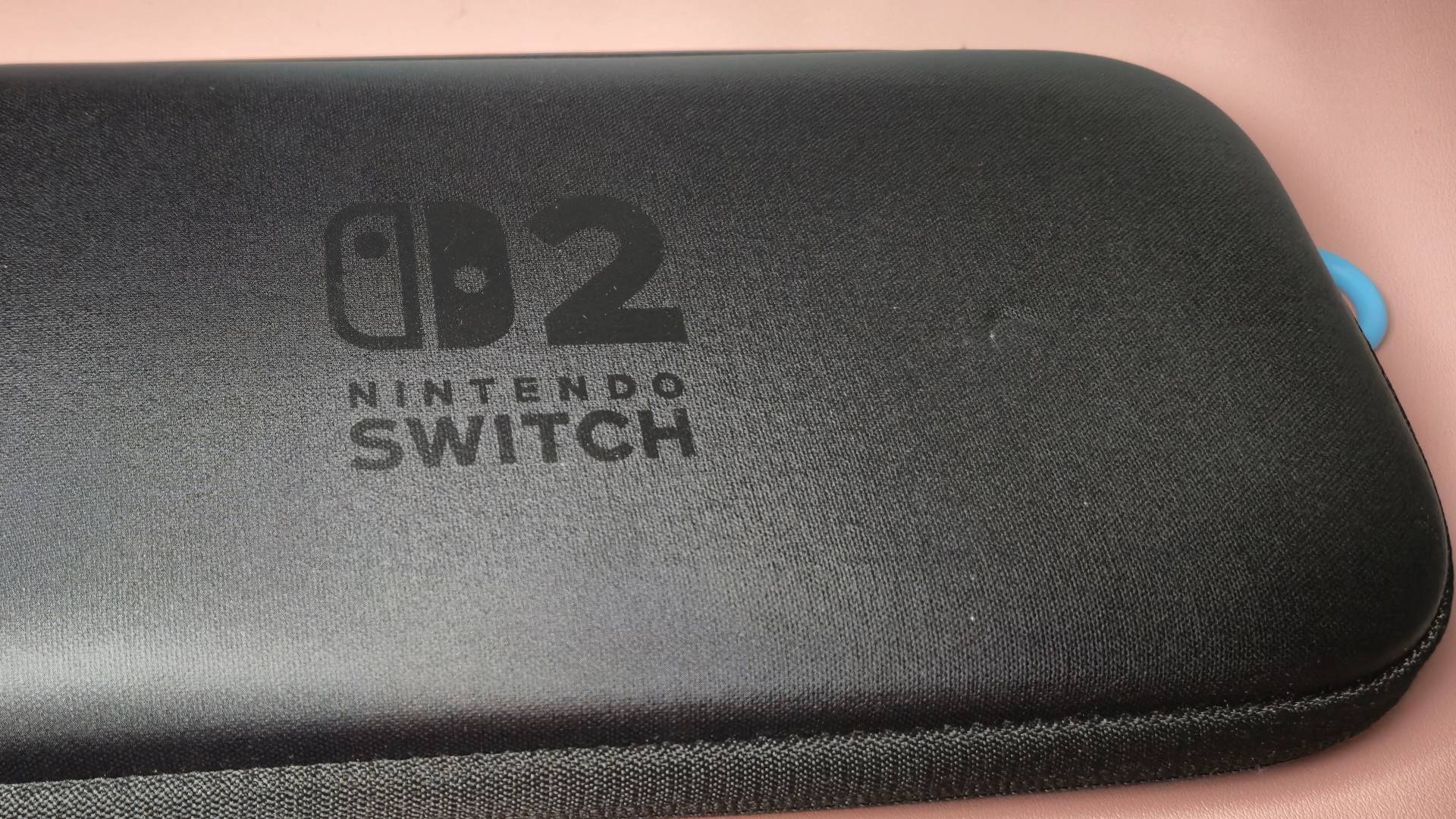 Photo of the official Switch 2 carrying case sitting on a pink desk.