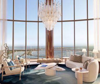 A living room with very high ceilings and floor to ceiling windows with a coastline view