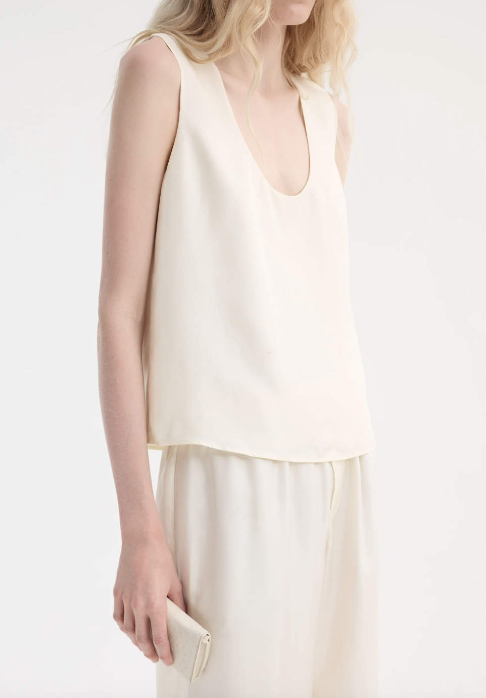 a model wearing a white scoop neck tank top from Rohe