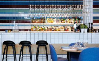 Bar with colourful tiles & full shelves of spirits