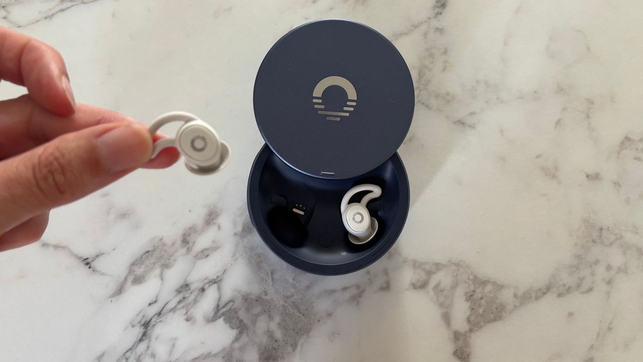 The image shows the Ozlo Sleepbuds 2 in their blue case on a marble worktop