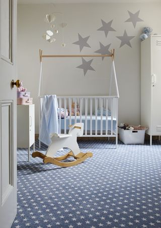Nursery with cot, rocking horse and blue carpet with white star pattern