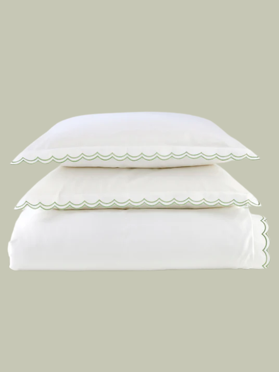 A white bedding set with a green scalloped border from Christy