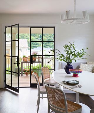 dining room with white oval table and steel framed windows