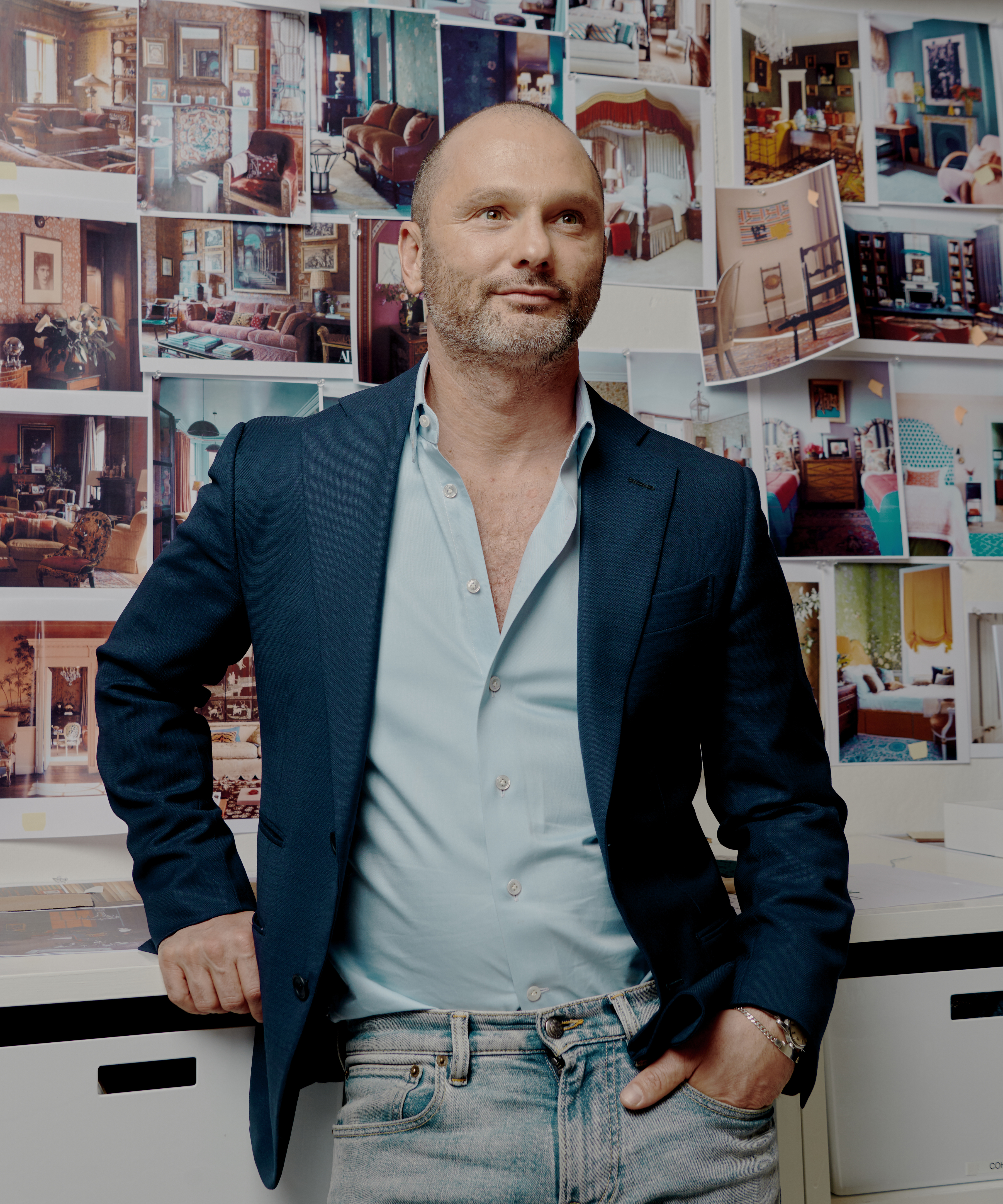 Billy Cotton standing in front of a moodboard in a blue blazer and jeans
