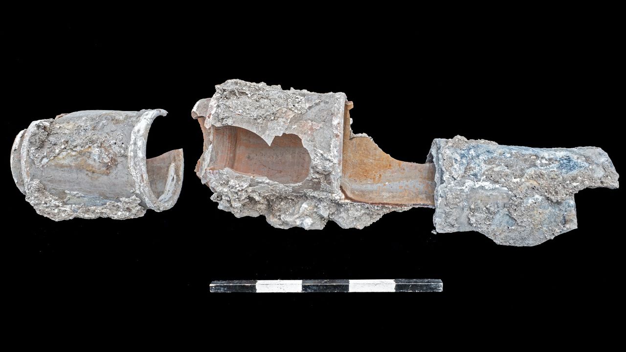 A close up of some very old Ottoman-Arab water pipes. They are quite worn with pieces missing.
