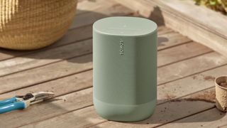 Un altavoz Sonos verde oliva sobre una tarima de madera