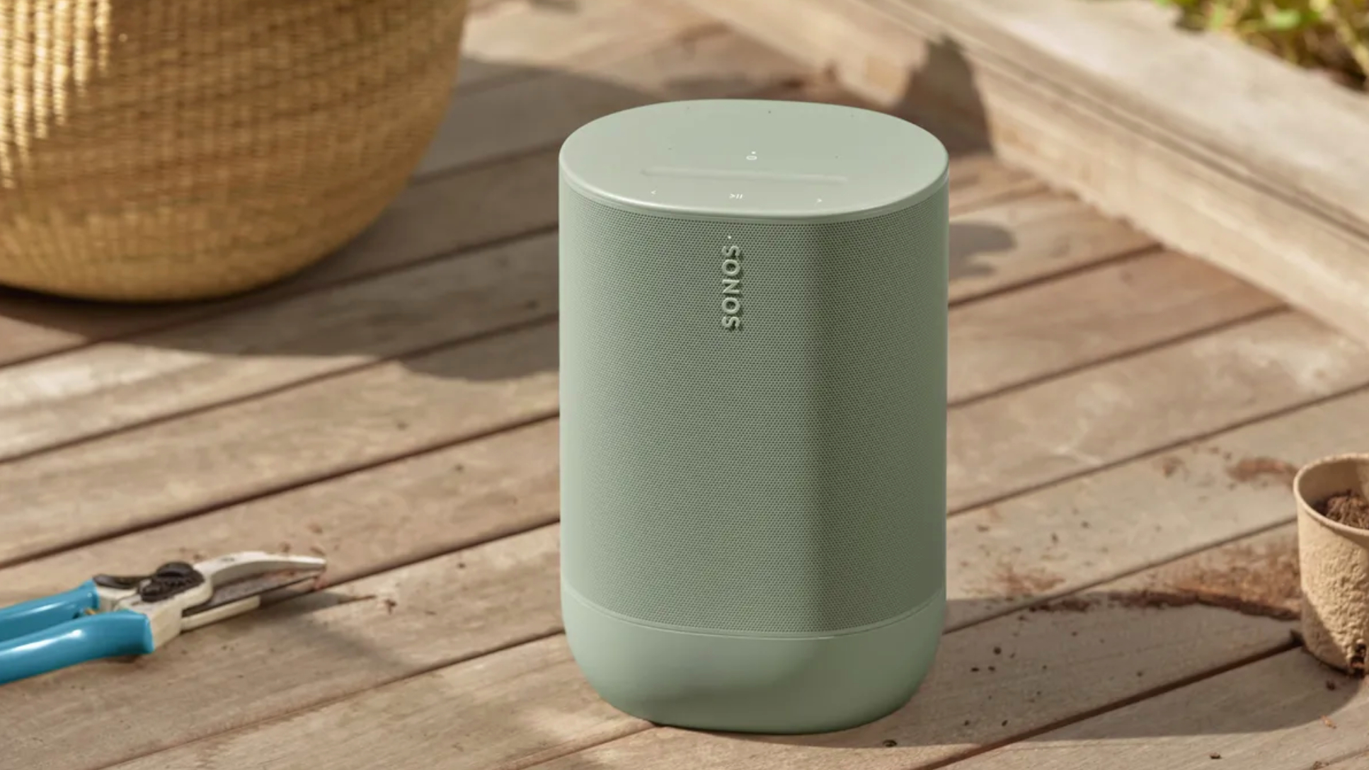 Une enceinte Sonos de couleur vert olive sur une terrasse en bois