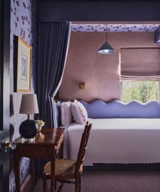 purple bedroom with canopy above the bed and curtain hanging down