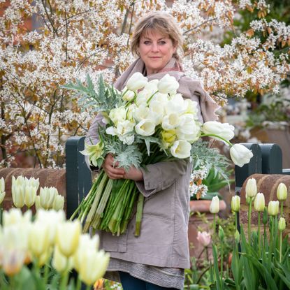 gardens expert Sarah Raven holding a large bunch of white tulips