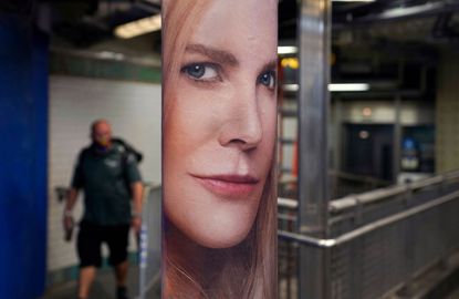 Man walks past Nine Perfect Strangers subway poster in the US