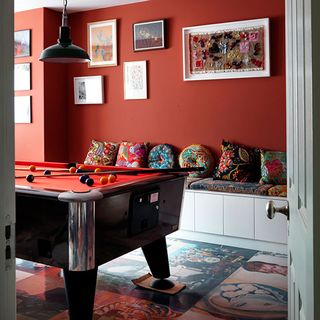 playroom with orange walls cushions and snooker table