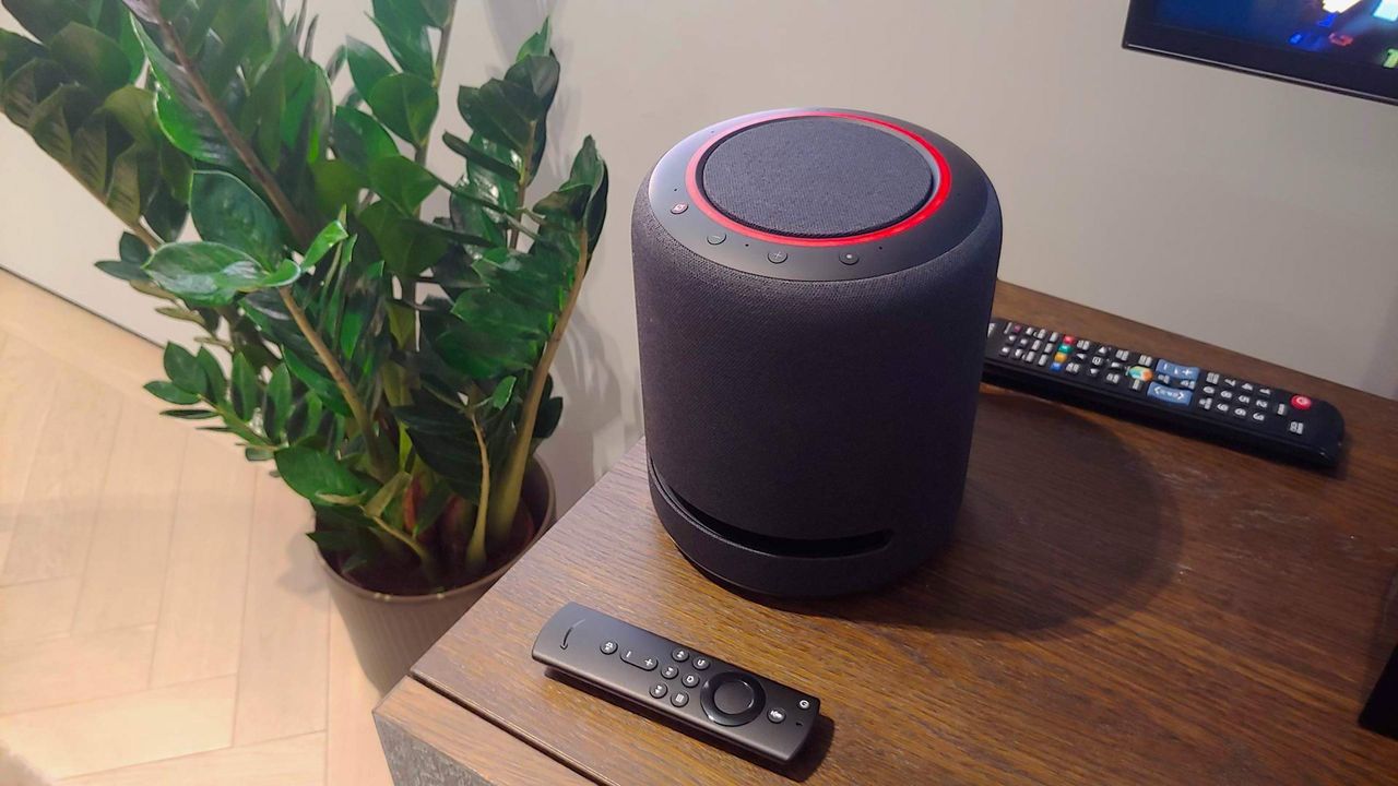 Amazon Echo Studio smart speaker on table with two remote controls