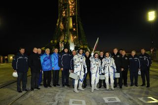 The Expedition 38 crew poses with the Olympic torch in front of the Russian Soyuz rocket just before launching toward the International Space Station on Nov. 7, 2013 local time from Baikonur Cosmodrome, Kazakhstan.