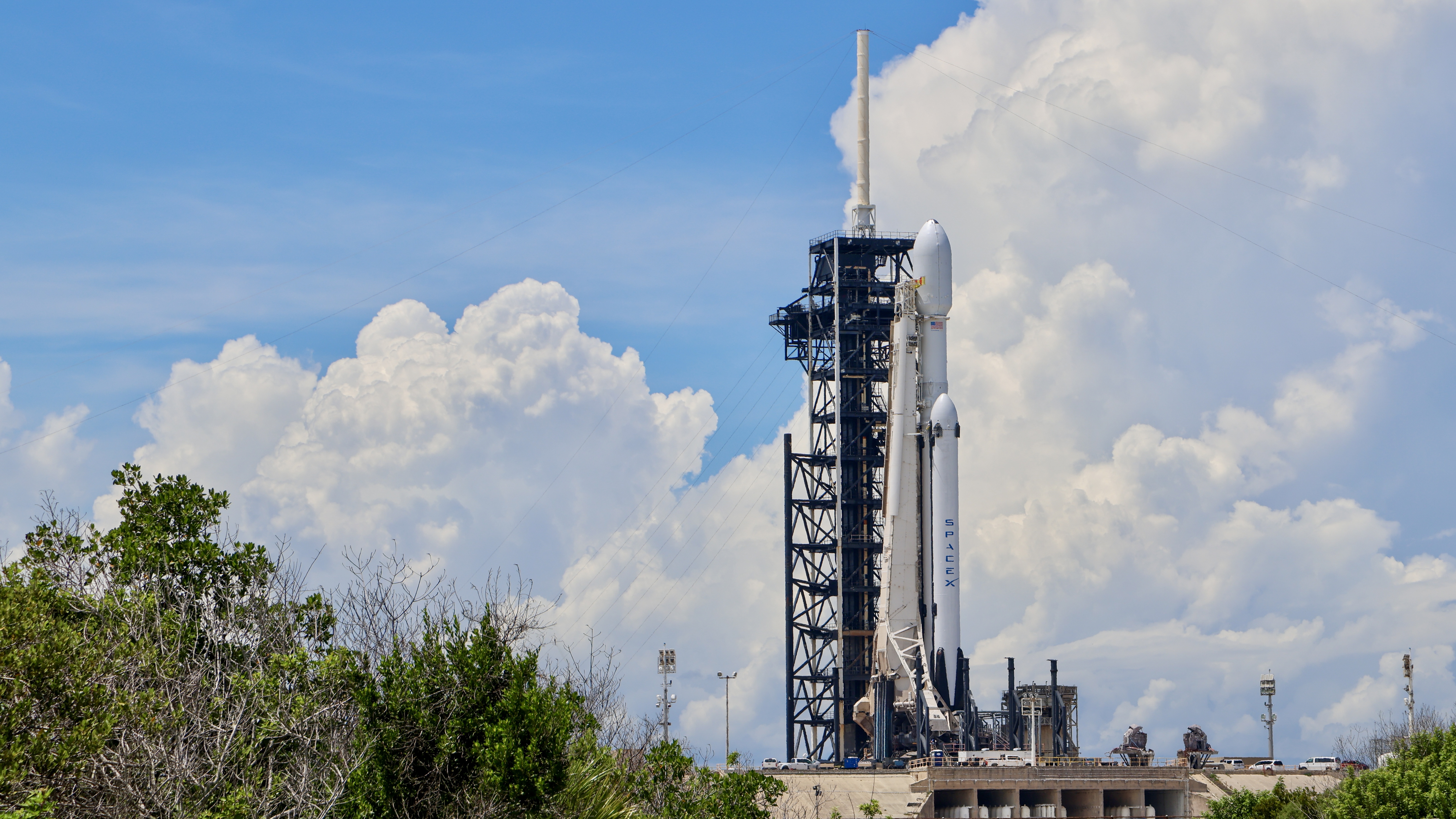 A triple core rocket stands at a launch pad.