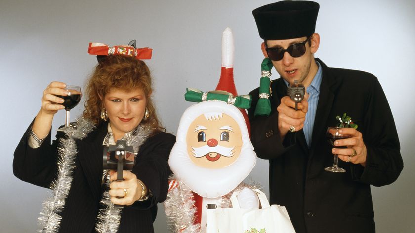 Singers Kirsty MacColl (1959 - 2000) and Shane MacGowan with with toy guns and an inflatable Santa in a festive scenario, circa 1987