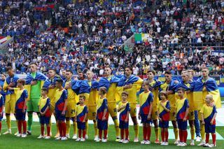 Players of Ukraine, seen wearing the national flag of Ukraine, sing the national anthem prior to the UEFA EURO 2024 group stage match between Slovakia and Ukraine at Düsseldorf Arena on June 21, 2024 in Dusseldorf, Germany