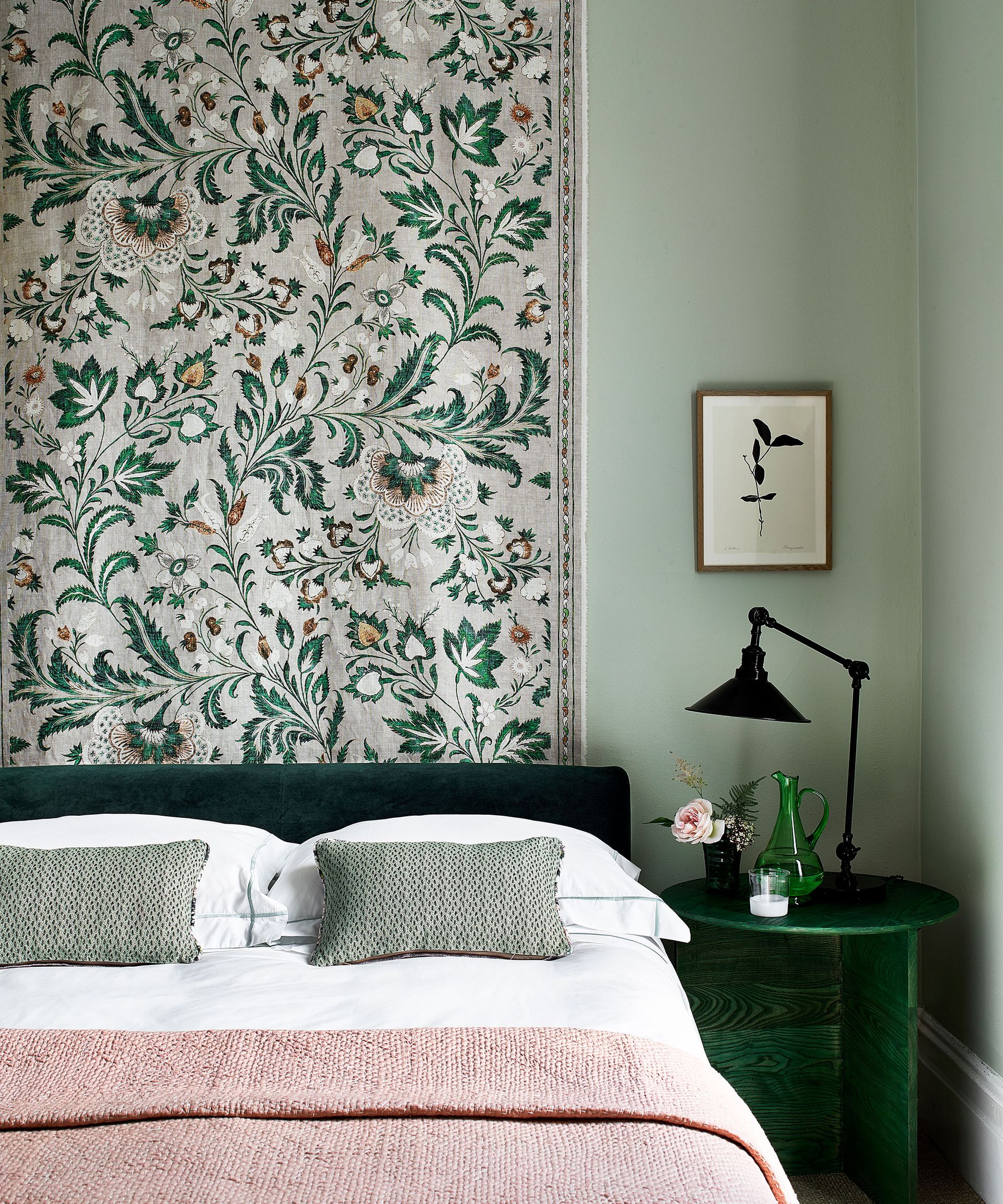 Small bedroom ideas with a fabric wall covering in a pale green scheme with muted pink accents.