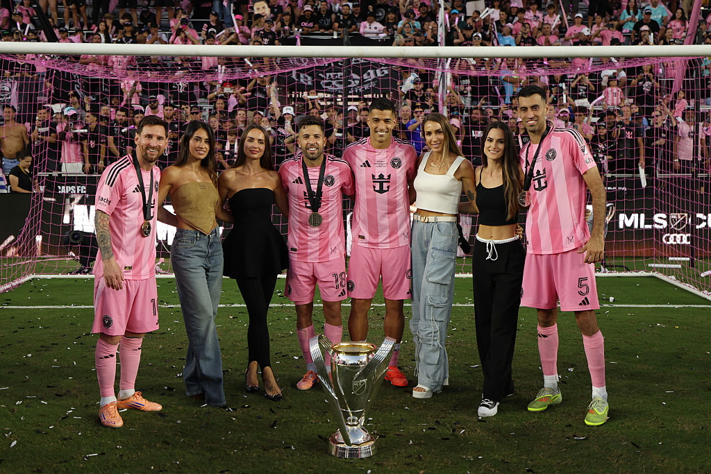 Lionel Messi #10, Antonela Roccuzzo, Romarey Ventura, Jordi Alba #18, Luis Suárez #9, Sofia Balbi, Elena Galera and Sergio Busquets #5 of Inter Miami CF celebrate with the trophy after winning the Audi 2025 MLS Cup Final match between Inter Miami CF and Vancouver Whitecaps FC at Chase Stadium on December 06, 2025 in Fort Lauderdale, Florida