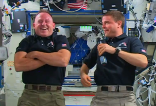 NASA astronauts Barry "Butch" Wilmore (left) and Reid Wisman (right) speak with NASA administrator Charles Bolden on Oct. 28, 2014.