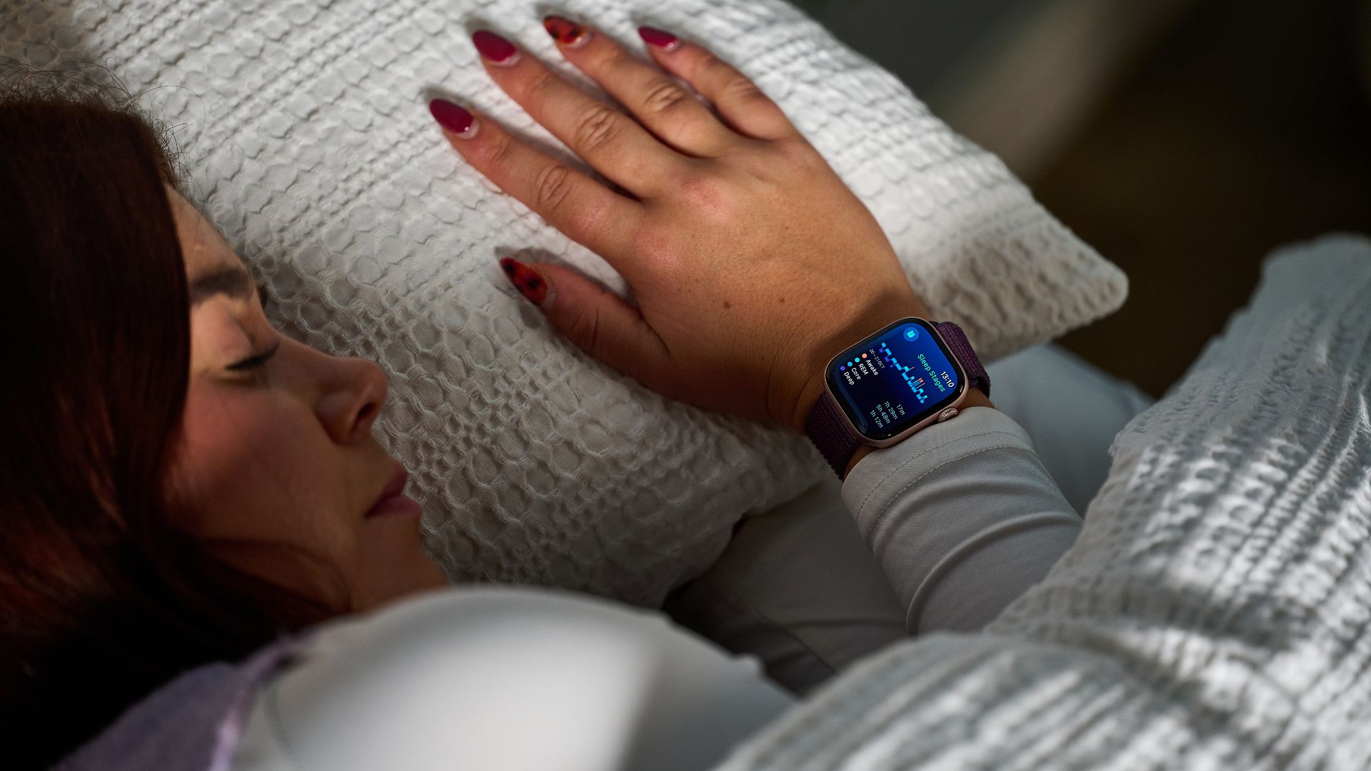 Tom's Guide's sleep tech tester in bed testing the Apple Watch 10. The watch shows a screen displaying sleep stages for the night.