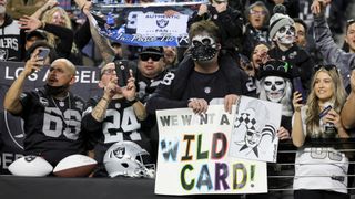 Las Vegas Raiders fans hold up signs before a game between the Raiders and the Los Angeles Chargers 
