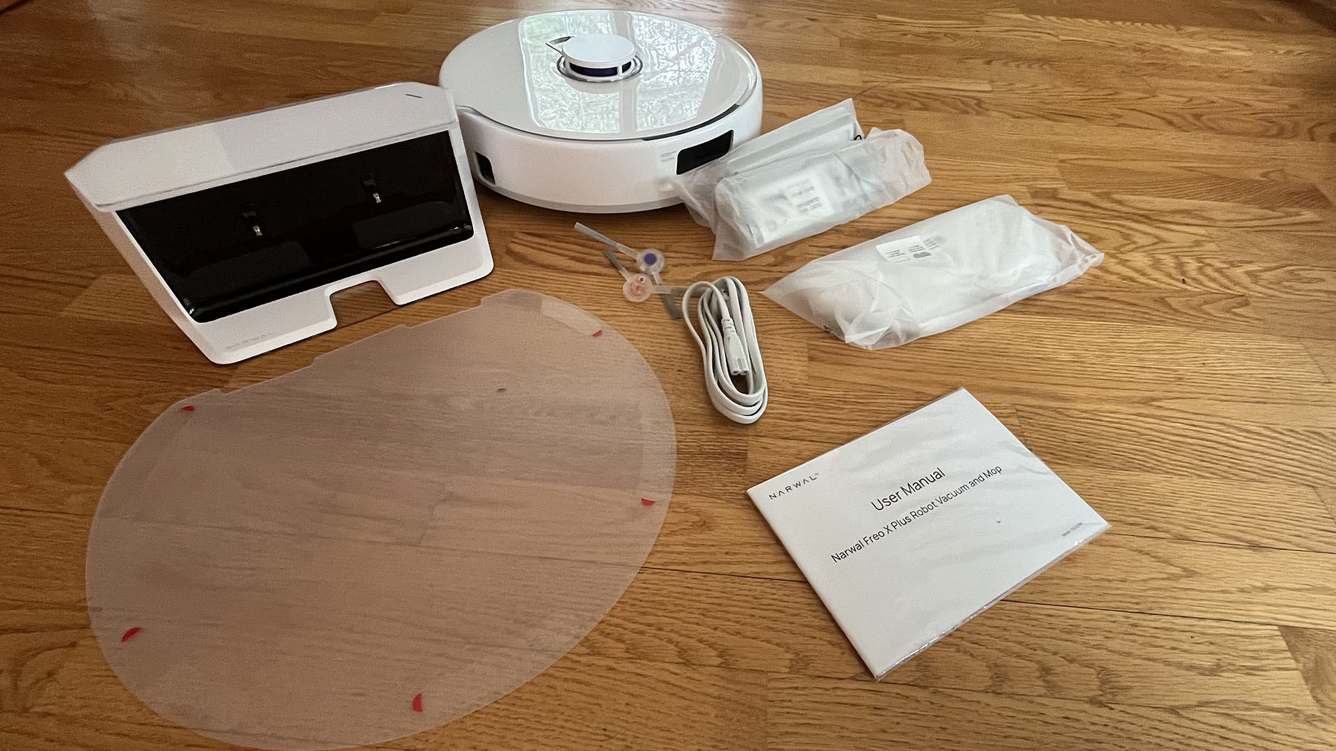 All components of Narwal Freo X Plus robot vacuum and mop laid out in reviewer's home