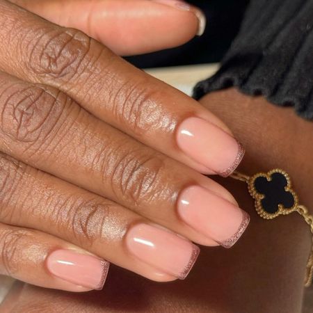 A short, square, brown, cat-eye French tip manicure