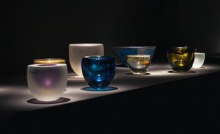 Coloured glass bowls on display in dark room