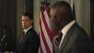 John Cena looks at Idris Elba while giving a speech in Heads of State.