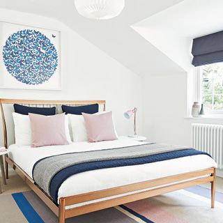 bedroom interror with white walls and bedding with blue cushions